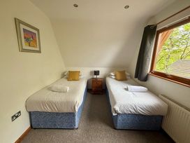 A bedroom with two single beds and a window at Acorn Lodge Finlakes Holiday Park near Chudleigh