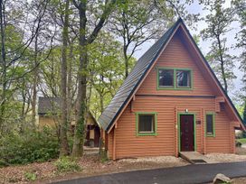 A cabin surrounded by trees at Acorn Lodge Finlakes Holiday Park near Chudleigh