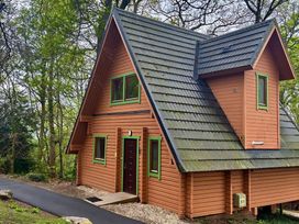 A wooden cabin with a sloped roof at Acorn Lodge Finlakes Holiday Park near Chudleigh