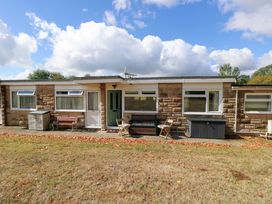 An outdoor view of a chalet with a front door and seating at No 157 Sandown Bay Holiday Chalet 'Field View' Sandown