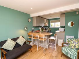 A kitchen with bar stools and a sofa at No 157 Sandown Bay Holiday Chalet 'Field View' Sandown