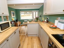 A kitchen with a table and chairs at No 157 Sandown Bay Holiday Chalet 'Field View' in Sandown