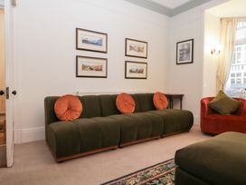 A living room with a green sofa and red armchair at Norwood House in Ambleside