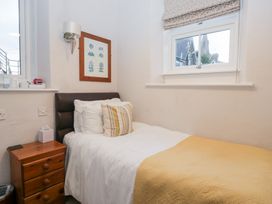A bedroom with a single bed and a bedside table at Norwood House in Ambleside