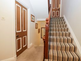A hallway with stairs and a door at Norwood House in Ambleside