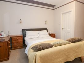 A bedroom with a bed and nightstands at Norwood House in Ambleside