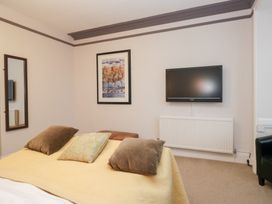A bedroom with a bed and television at Norwood House in Ambleside