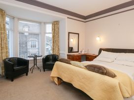 A bedroom with a bed and seating area at Norwood House in Ambleside