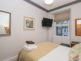 A bedroom with a bed and television at Norwood House in Ambleside