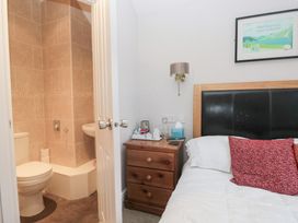 A bedroom with a bed and an en-suite bathroom at Norwood House in Ambleside