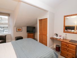 A bedroom with a bed, television, and dresser at Norwood House in Ambleside