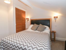 A bedroom with a bed and wardrobe at Norwood House in Ambleside