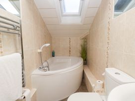 A bathroom featuring a bath and toilet at Norwood House in Ambleside
