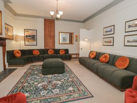 A living room with a green sofa and an ottoman at Norwood House in Ambleside