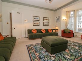 A living room with green sofas and a rug at Norwood House in Ambleside