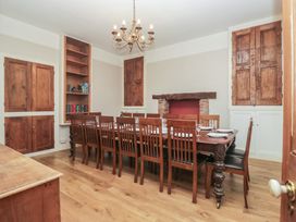 A dining room with a long table and wooden chairs at Norwood House in Ambleside