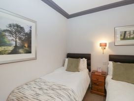 A bedroom with two single beds and a nightstand at Norwood House in Ambleside