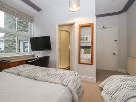A bedroom with a bed, television, and shower at Norwood House in Ambleside