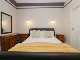 A bedroom with a bed, mirror, and dresser at Norwood House in Ambleside