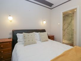 A bedroom with a bed and a shower area at Norwood House in Ambleside