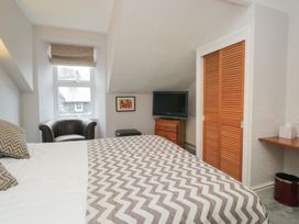 A bedroom featuring a bed, television, and drawer at Norwood House in Ambleside