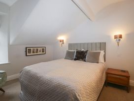 A bedroom with a bed, bedside table, and wall decorations at Norwood House in Ambleside
