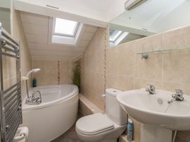 A bathroom with a bath tub, sink, and toilet at Norwood House in Ambleside