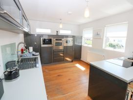 A kitchen with appliances and cabinetry at Shearwater in Rhosneigr