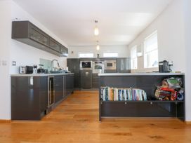 A kitchen with cupboards, sink, and appliances at Shearwater in Rhosneigr
