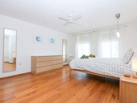 A bedroom with a bed and dresser at Shearwater Rhosneigr
