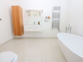 A bathroom with a bathtub, sink, and toilet at Shearwater in Rhosneigr