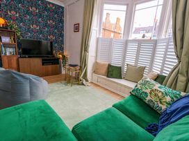A living room with a television and bookshelf at Seagull & Chips in Weymouth