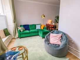 A living room with a green sofa and bean bag at Seagull & Chips in Weymouth