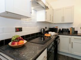 A kitchen with a stove, microwave, and fruit on the counter at Seagull & Chips in Weymouth