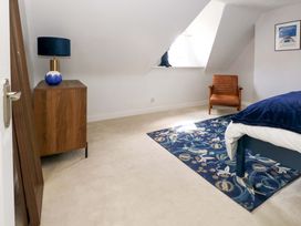 A bedroom with furniture including a bed, side table, and lamp at Seagull & Chips in Weymouth