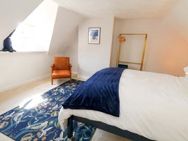 A bedroom with a bed and chair at Seagull & Chips in Weymouth
