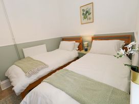 A bedroom with two beds and a bedside table at Seagull & Chips in Weymouth
