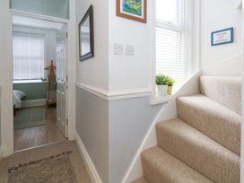 A hallway with stairs and a mirror at Seagull & Chips in Weymouth