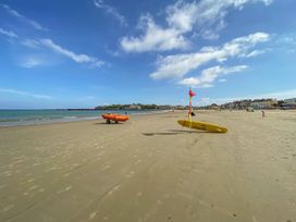 A beach with lifeguard boat and surfboard at Seagull & Chips in Weymouth