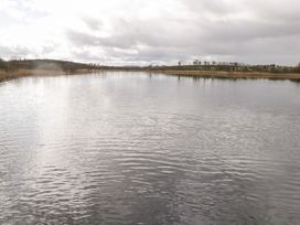 A body of water with surrounding land and cloudy sky at Huath in Carrick on Shannon
