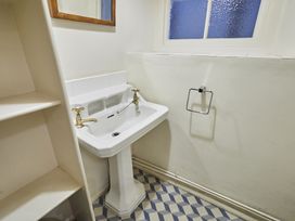 A sink and mirror in a bathroom at Beachside Cottage Sandsend