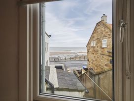 A view of the beach and houses from a window at Beachside Cottage in Sandsend