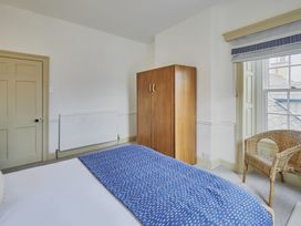 A bedroom with a bed and a wardrobe at Beachside Cottage in Sandsend