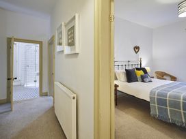 A bedroom with a bed and door to bathroom at Beachside Cottage in Sandsend
