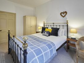 A bedroom with a bed and wardrobe at Beachside Cottage in Sandsend