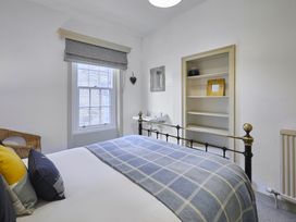 A bedroom with a bed, window and shelves at Beachside Cottage in Sandsend