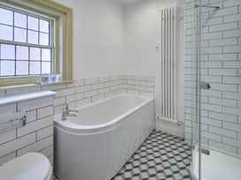 A bathroom with a bathtub, shower, and window at Beachside Cottage in Sandsend