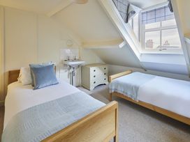 A bedroom with two beds and a sink at Beachside Cottage in Sandsend