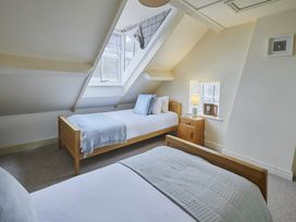 A bedroom with two beds and a nightstand at Beachside Cottage in Sandsend