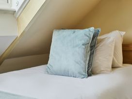 A bed with pillows at Beachside Cottage in Sandsend